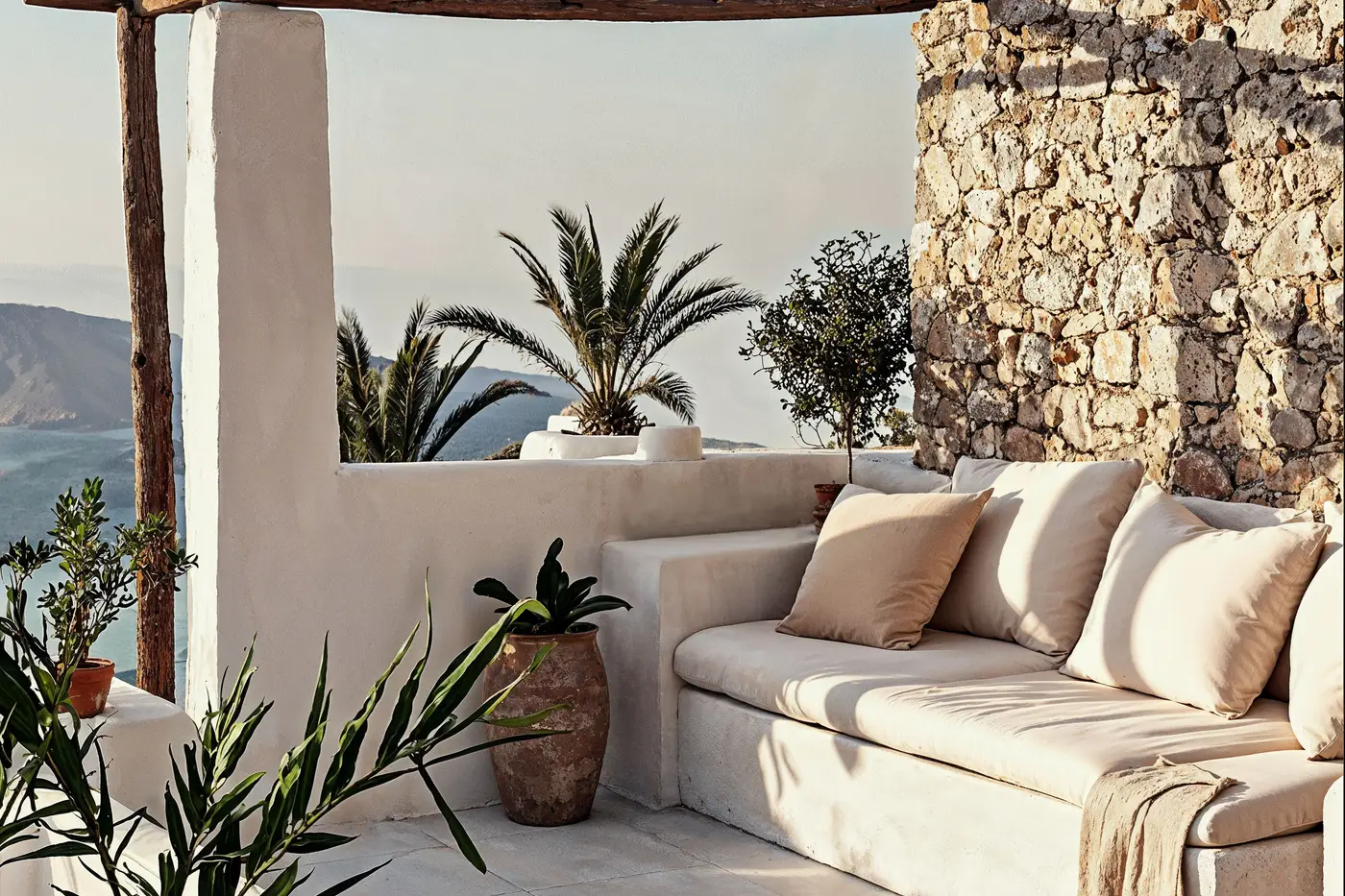 A stone terrace with built-in seating under a timber pergola